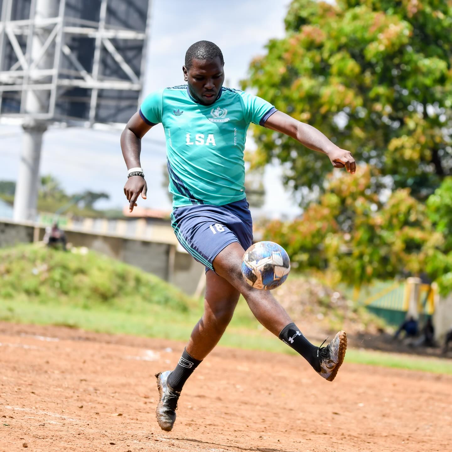 A Nairobi West player striking the ball on a branch league pitch